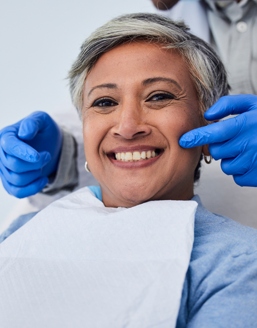 Senior man looking in a mirror at a dentist's office. About 65 years old, Caucasian male.